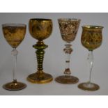 Four gilt hand decorated wine glasses including a signed example, tallest 21cm