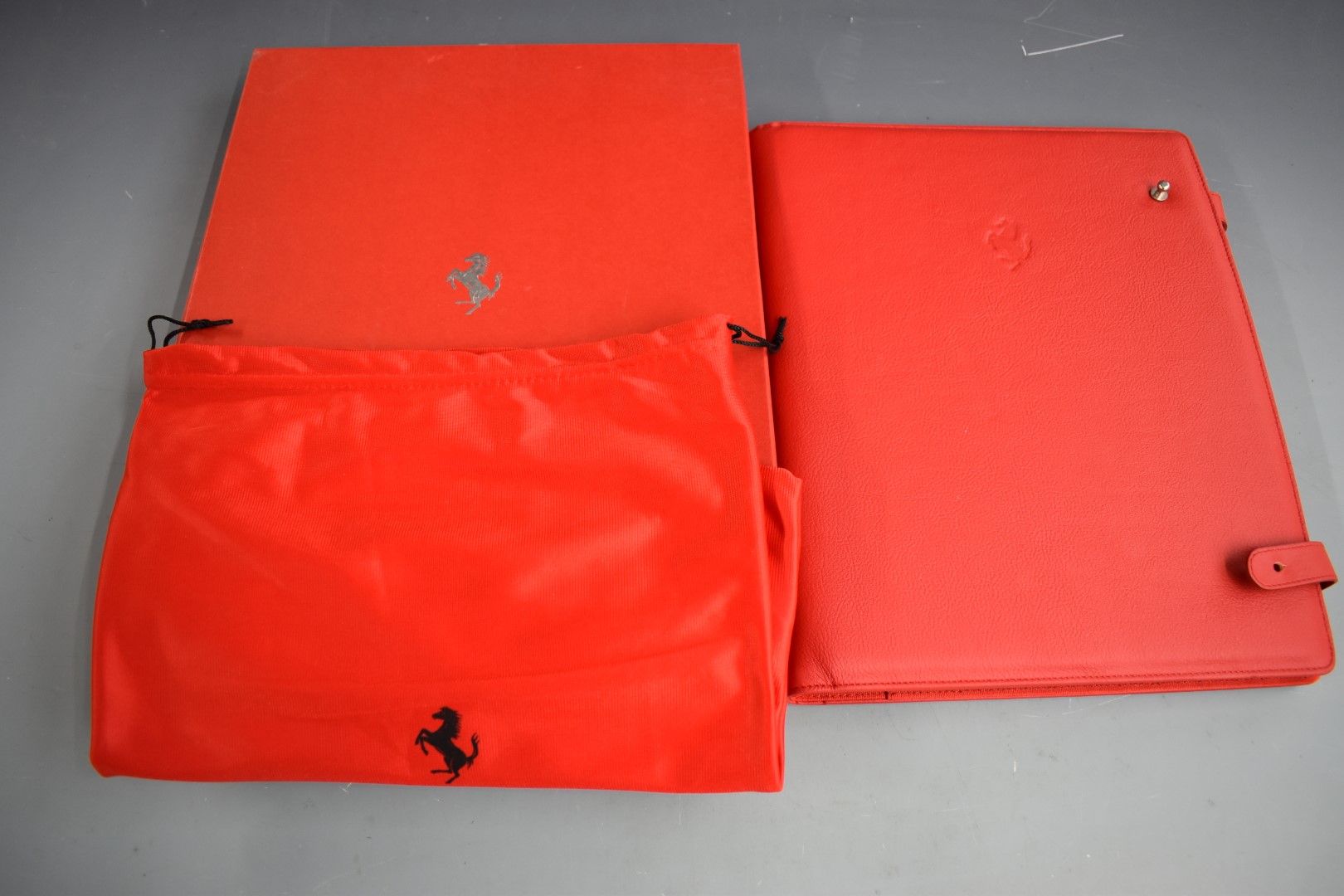 Ferrari red leather organiser, in original box with drawstring carry bag