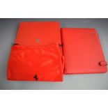 Ferrari red leather organiser, in original box with drawstring carry bag