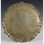 George V hallmarked silver salver with shaped edge, raised on three feet, inscribed to centre to