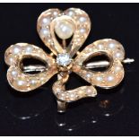 A 14k gold pendant/ brooch in the form of a clover/ shamrock set with seed pearls, pearl and a