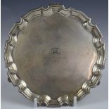George V hallmarked silver card tray with shaped edge, raised on three scrolling feet, Birmingham