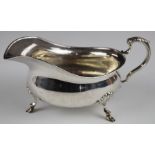 George V hallmarked silver sauce or gravy boat with beaded edge and scrolling handle, raised on