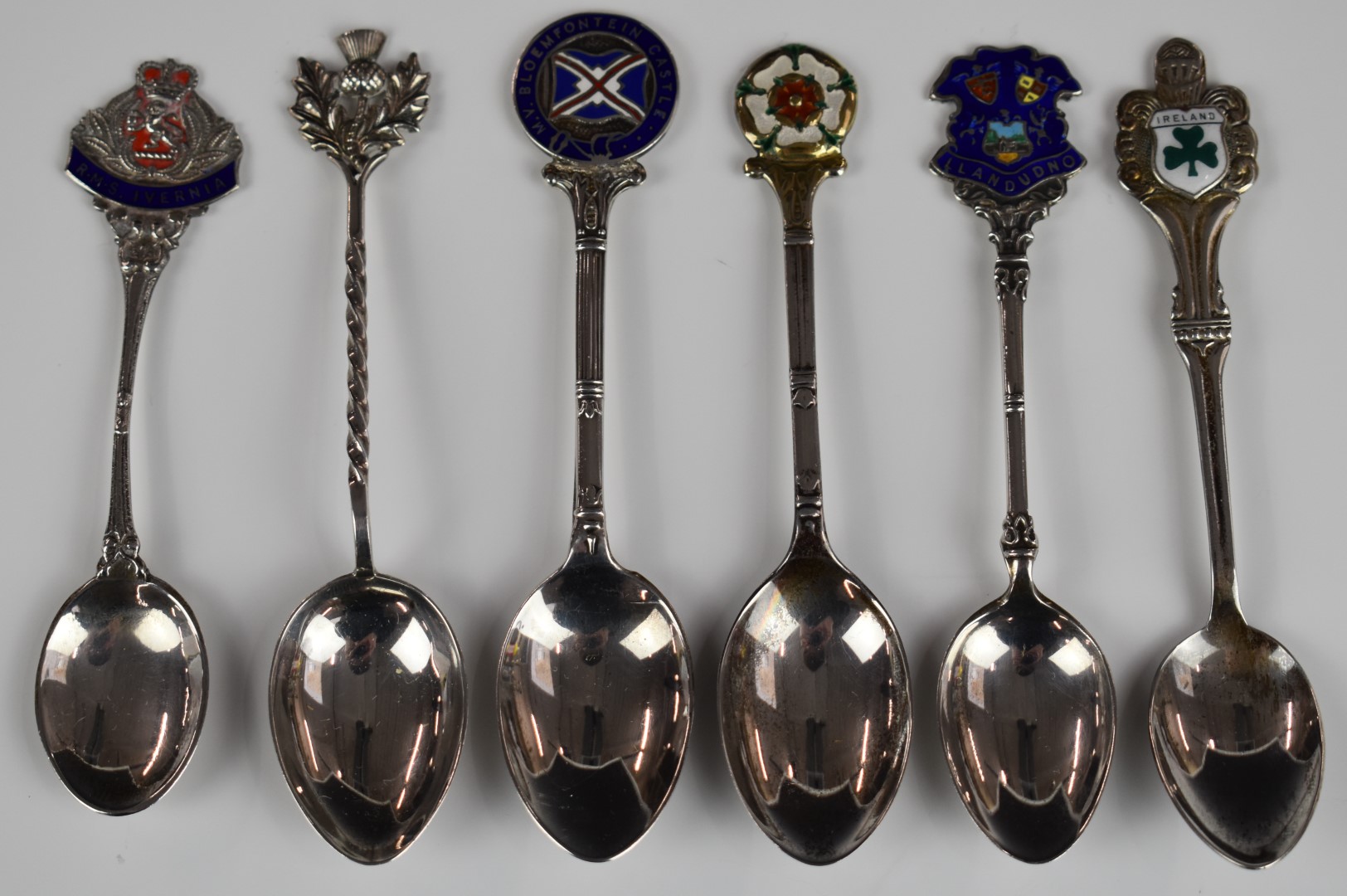 Six hallmarked silver souvenir spoons, most having enamel decoration, to include Llandudno,