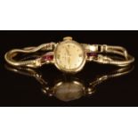 Omega 9ct gold ladies wristwatch with gold hands and hour markers, champagne dial, ruby set case and