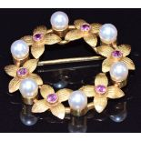 A 9ct gold brooch set with pearls and rubies in a floral setting, 4.7g