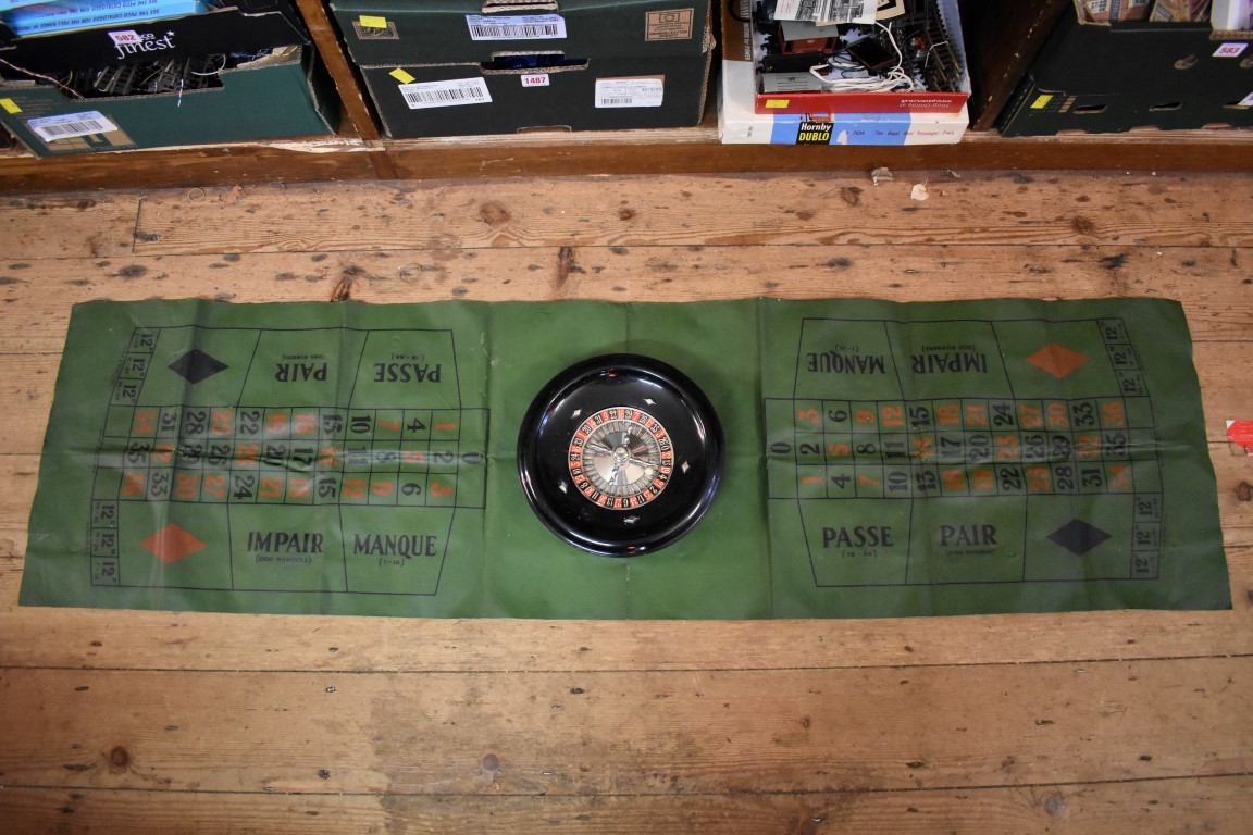 A vintage roulette wheel, 24.5cm diameter, boxed and with playing mat.