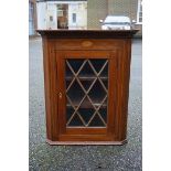 An inlaid mahogany hanging corner cupboard, 68.5cm high, (no key).Payment must be made in advance of