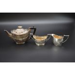 A composite Victorian silver bachelor's three piece tea set, by James Deakin & Sons, Sheffield