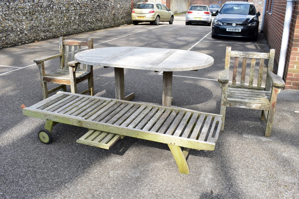 A teak garden table, 181 x 120cm; together with a pair of teak armchairs and a teak lounge chair.