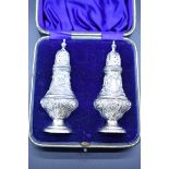 A cased pair of Edwardian silver pepperettes, by W Hutton & Sons Ltd, Birmingham 1910, 12cm, 61g.