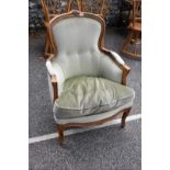 An antique beech button back armchair.