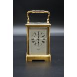 An antique brass carriage clock, striking on a gong, the enamel dial inscribed 'Carrington',