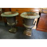 A pair of Victorian cast iron twin handled pedestal urns, 70cm high.