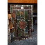 A set of three Victorian stained and leaded glass rectangular panels, each painted to the centre