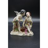 A continental porcelain figure group of two putti, 17cm high.