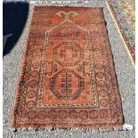 An Afghan rug, having three central medallions on an orange ground, 135 x 80cm.