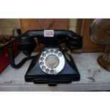 A vintage black Bakelite telephone, with apron drawer.