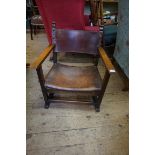 An early 20th century oak and leather child's open arm elbow chair.