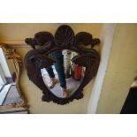 An unusual antique carved walnut framed wall mirror, the egg shaped plate flanked by dodos, 76 x