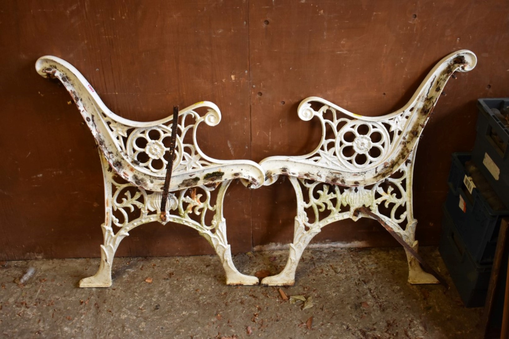 A pair of white painted cast iron bench ends, 73cm high x 60cm wide.