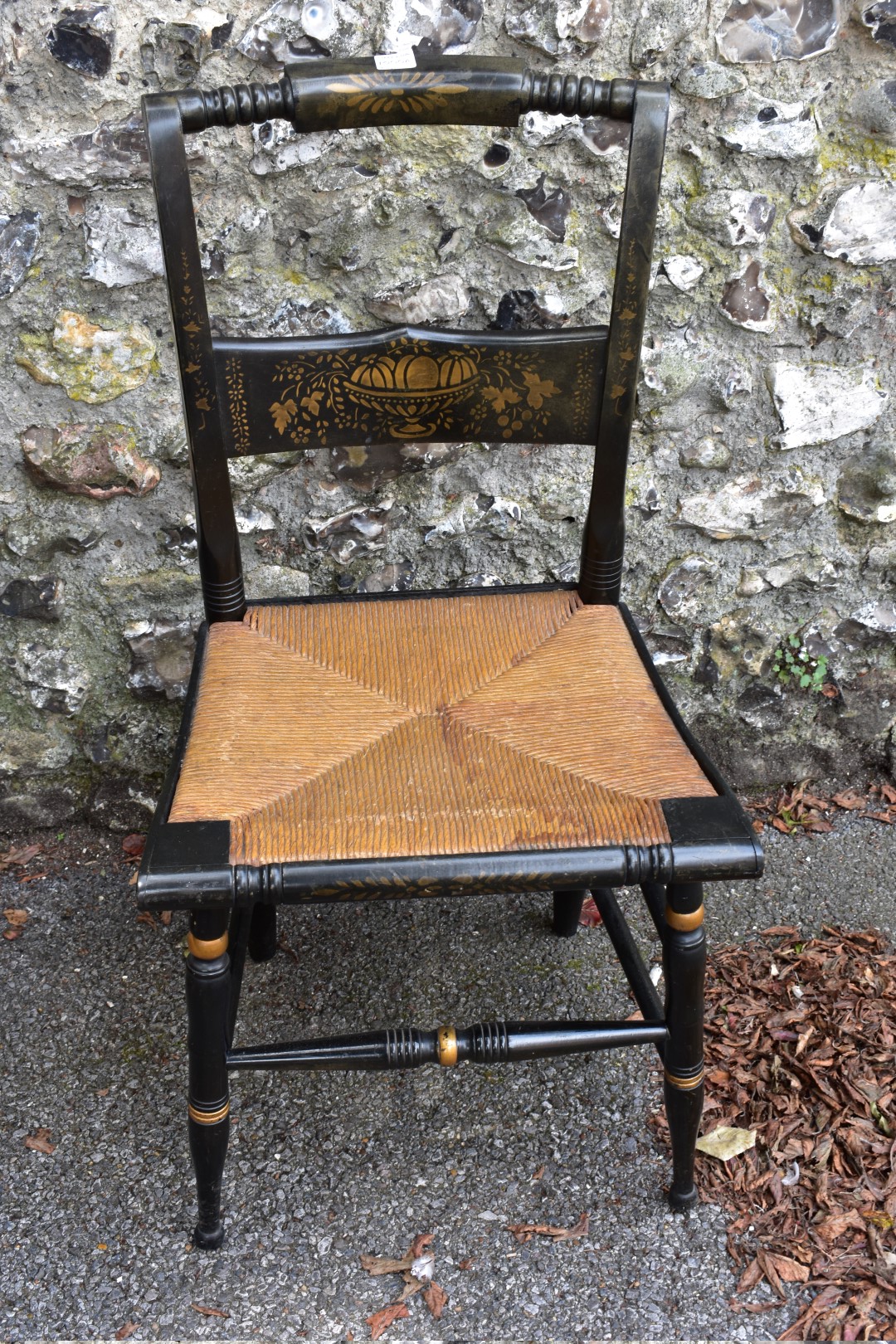 An ebonized cane seated chair, having gilt decoration.