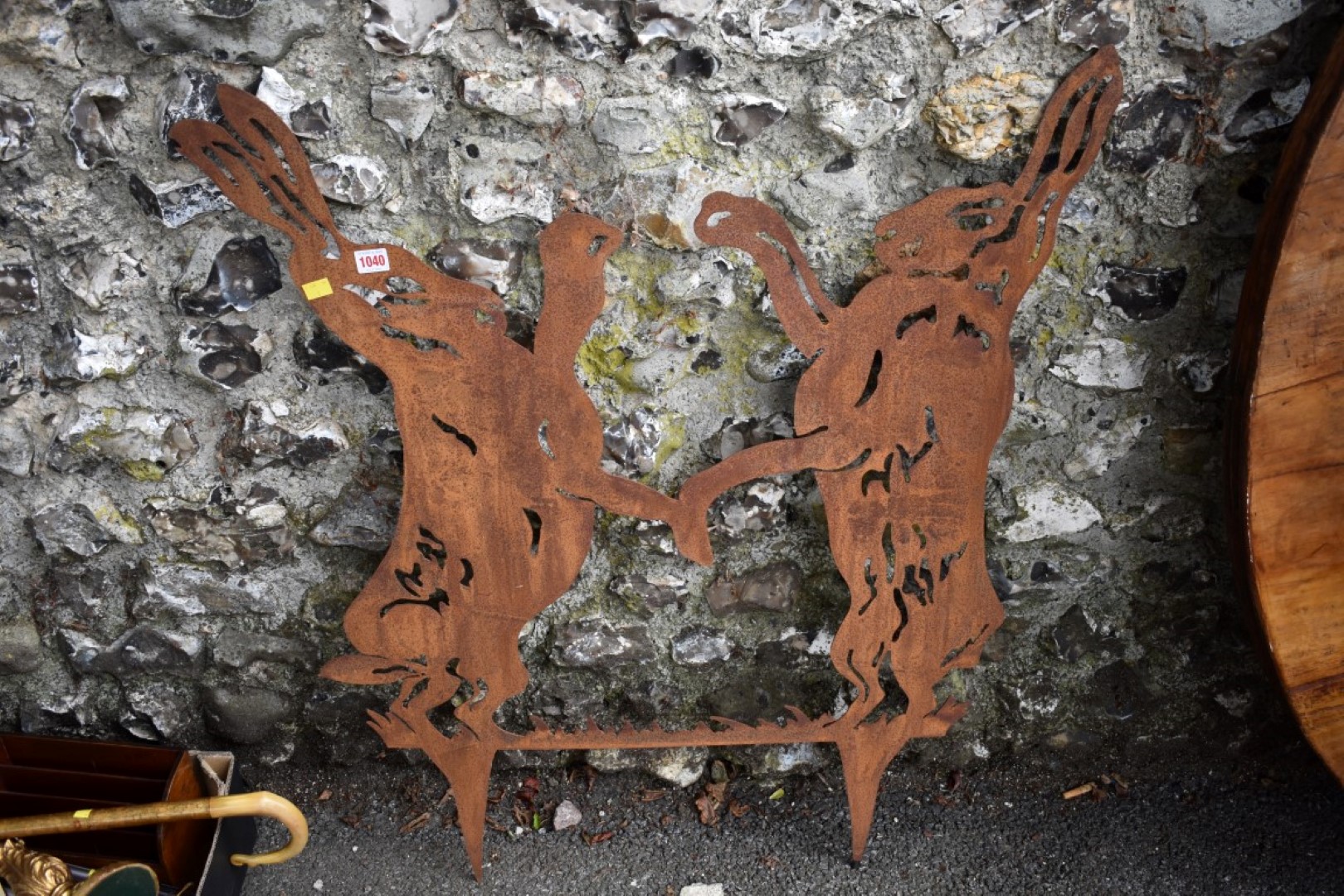 A steel garden ornament of fighting hares.