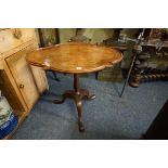 An old walnut and mahogany tilt-top tripod table, of shaped outline, 75cm wide, (repair to one leg).