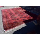 A large Bokhara carpet, having repeated central field on a red ground, 344 x 262cm.