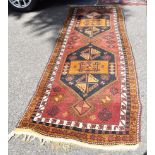 A large Afghan runner, having two central diamonds with geometric borders, 366 x 102cm.