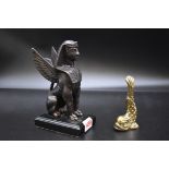 A bronze sphinx, on slate base, 17.5cm high; together with a small brass dolphin paperweight,
