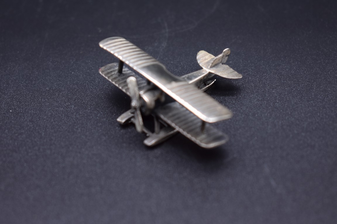 A silver model of a biplane, 5cm wingspan, import mark Birmingham 2000, 20g.