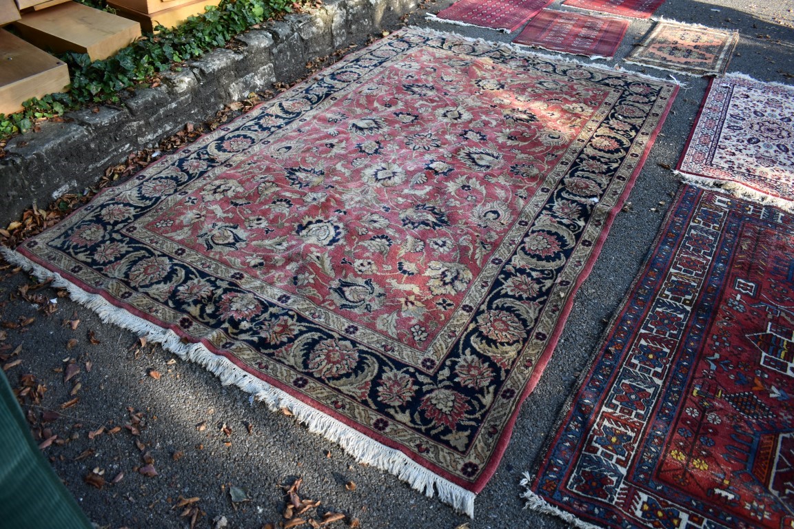 A floral rug, central field decorated with flowers and deer, with floral borders.