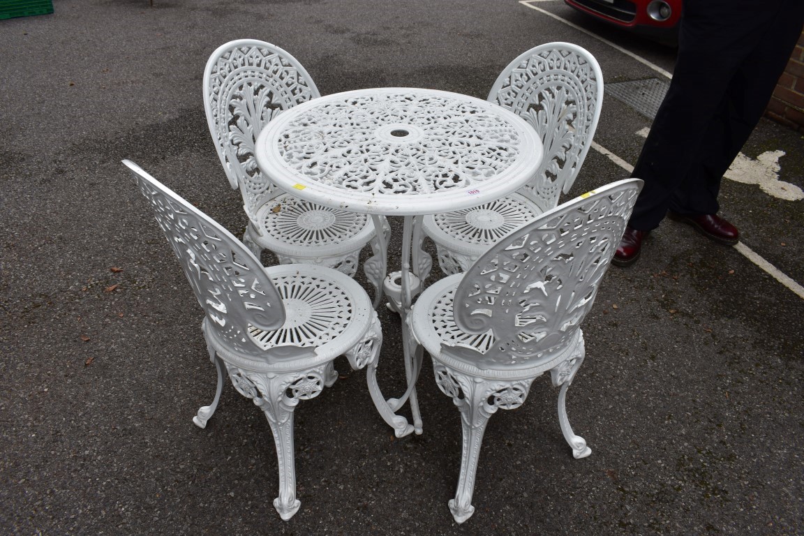 An aluminium white painted garden table; together with four matching chairs.