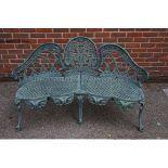 A green painted cast iron garden bench, 136cm wide.