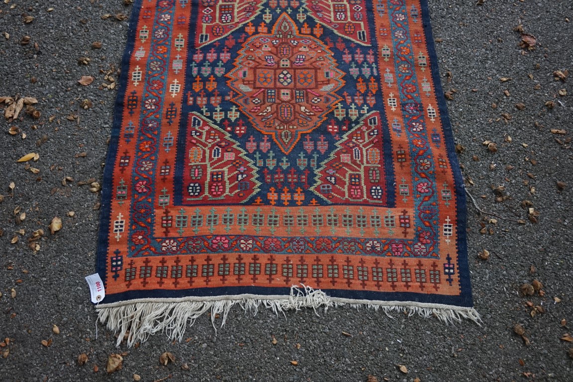 A long Tribal runner, having seven central medallions, with floral borders on a red and blue ground, - Image 2 of 10