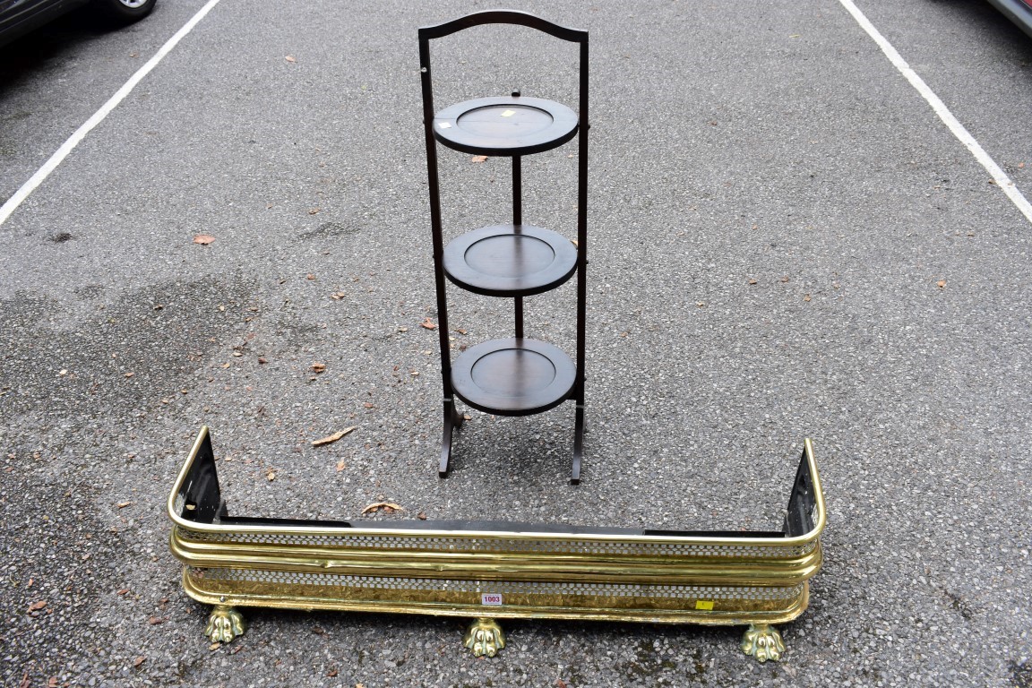 A brass fire fender, 103cm wide; together with a folding cake stand.