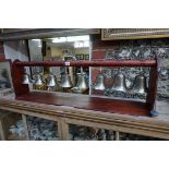 A set of eight musical bells, one inscribed 'S Chaundler - 1711', on stained pine stand.
