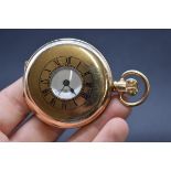 A 10k rolled gold half hunter stem wind pocket watch, 50mm, unsigned enamel dial, and Swiss