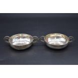 Two similar white metal twin handled wine tasters, probably 18th century continental, each 10cm
