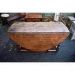 An antique oak gateleg table, 124cm wide.