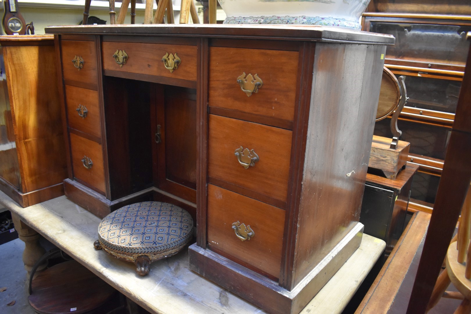 An early 20th century walnut kneehole pedestal desk, 122cm wide.