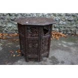 A carved octagonal folding table, 54cm wide x 54cm high, (a.f.); together with a small Eastern tray;