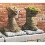 Garden statues: A similar pair of composition stone armorial grotesque heads, 58cm high, Part of the