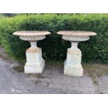 A pair of rare and unusually large Handyside foundry cast iron urns on pedestals