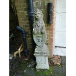 A pair of composition stone armorial lions on pedestals