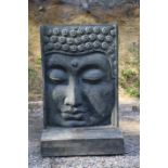 A composition stone wall fountain cast with a Buddha head