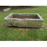 A rectangular carved stone trough