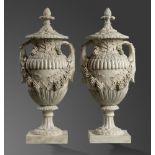 A pair of lidded plaster urns