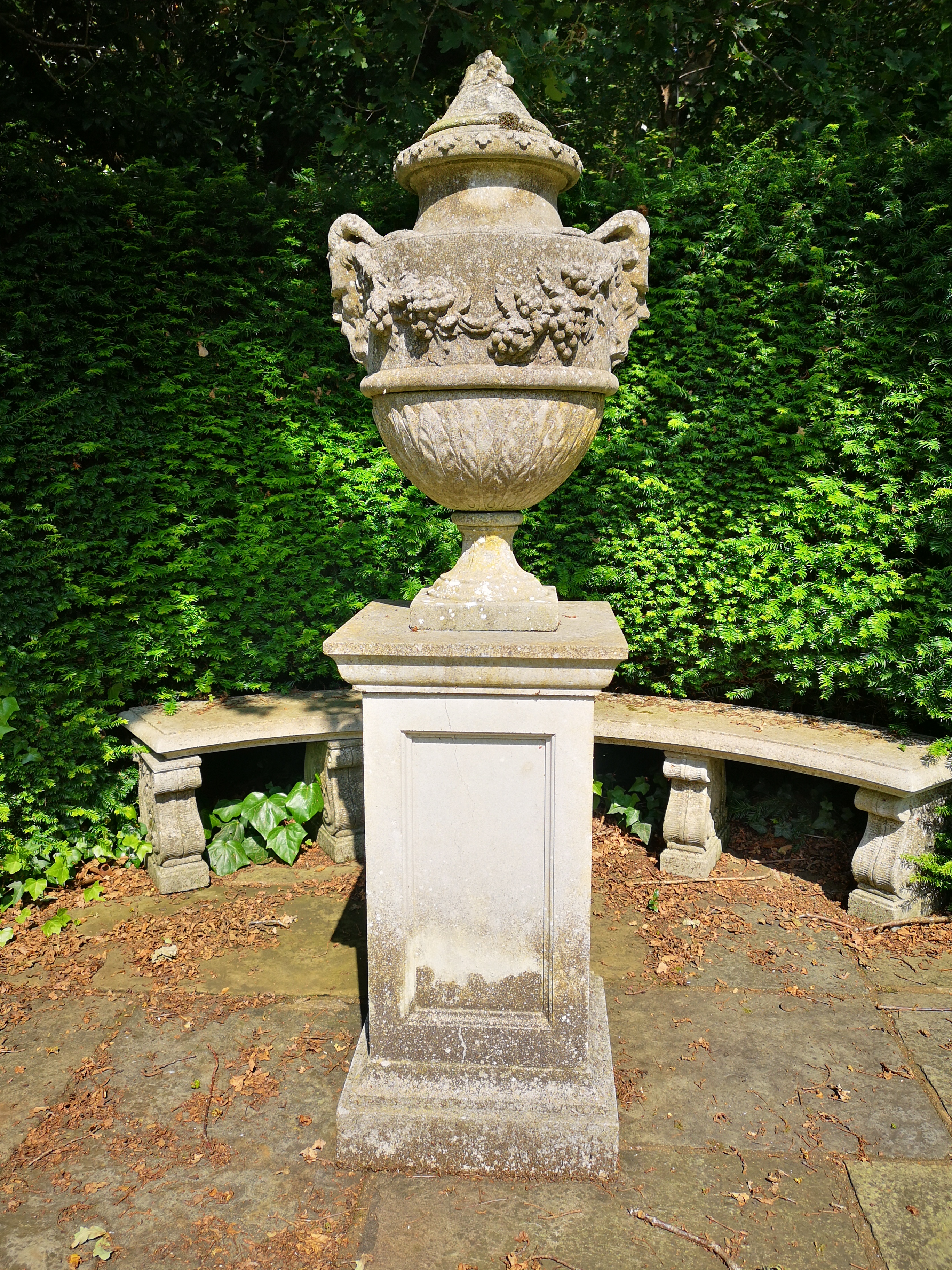 A composition stone finial on pedestal